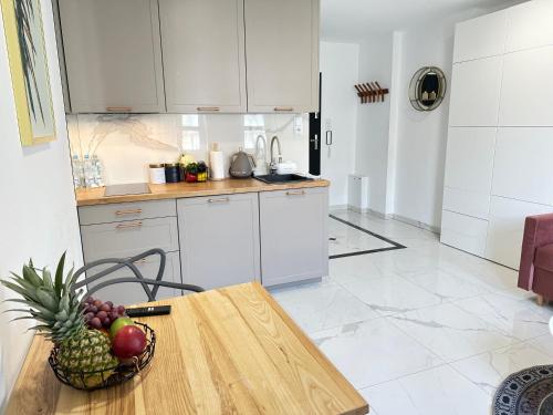 a kitchen with a table with a bowl of fruit on it at MOVEEN! Wynajem apartamentów we Wrocławiu! 10 minut od centrum in Wrocław