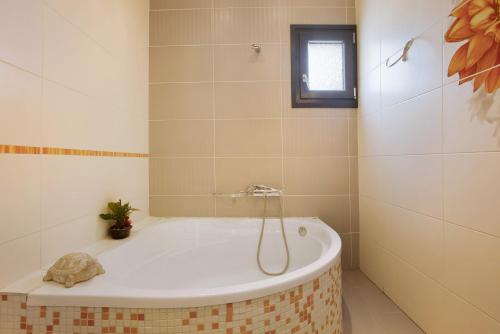 a bath tub in a bathroom with a window at Zante Sunset Vibes Luxury Villa in Áno Yerakaríon