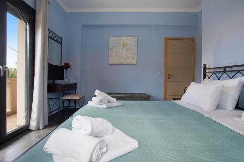 a bedroom with a bed with towels on it at Zante Sunset Vibes Luxury Villa in Áno Yerakaríon