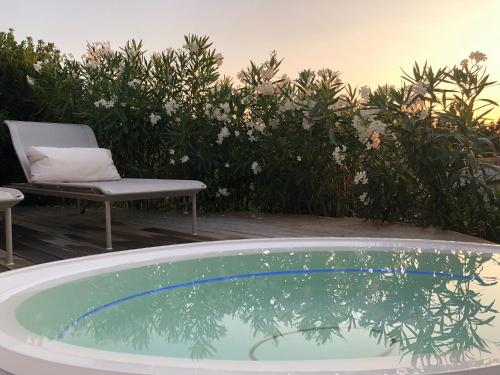 a hot tub on a patio with a chair and flowers at House Casbah Porto Rotondo in Porto Rotondo