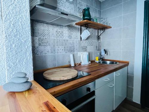 una pequeña cocina con encimera de madera y fregadero en Sea lover's nest, en Los Realejos