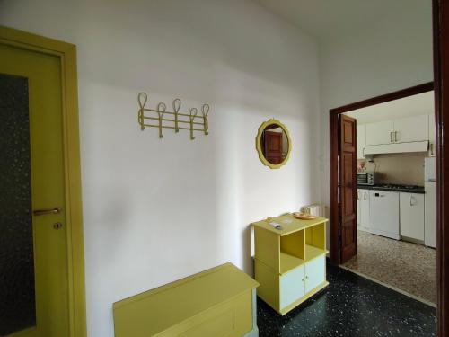 una cocina con una pared blanca y un armario amarillo en Appartamento Case Rosse, en Le Grazie