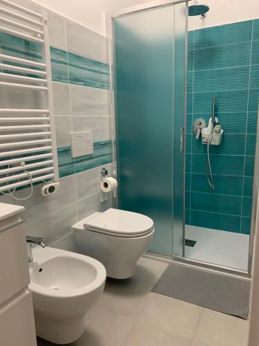 een badkamer met een toilet en een glazen douche bij La Fortuna in Quiliano
