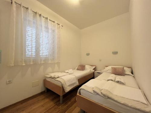 2 letti in una camera con finestra di Sun Haven Luxury Apartments a Cavtat