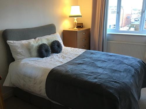 a bedroom with a bed with two pillows on it at Dovedale Apartment in Moreton