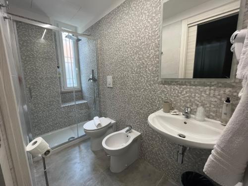 a bathroom with a sink and a toilet and a mirror at Gu Hotel in Guidonia