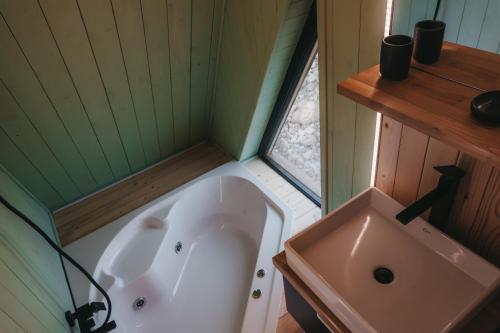 ein kleines Bad mit einer Badewanne und einem Waschbecken in der Unterkunft Haita Land in Vatra Dornei