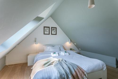 um quarto com uma cama branca num sótão em Bonrepo Room 105 em Bruges