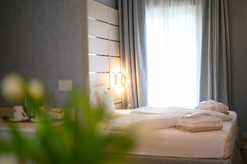 a hotel room with a bed and a window at Villa Nicolli Romantic Spa Resort - Adults Only in Riva del Garda