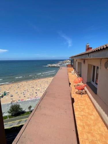 balcón con sillas y vistas a la playa en MyHouseSpain - Ático con terraza en la playa, en Gijón