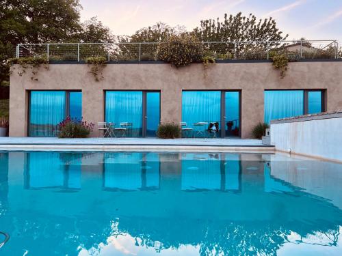 ein Haus mit blauen Fenstern und einem Pool in der Unterkunft PECORANERA in Bracciano