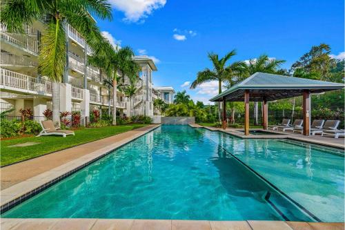 a swimming pool in front of a building with a gazebo at Absolute Luxury Marina Lifestyle at The Port of Airlie Beach in Airlie Beach
