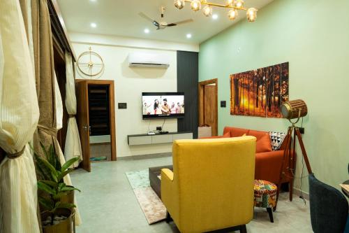 a living room with a yellow chair and a tv at Barefoot Homestays in Rāmnagar
