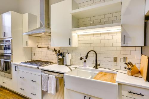 a kitchen with white cabinets and a sink at Downtown Omaha Getaway with Deck and Gas Grill! in Omaha