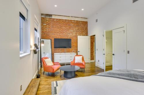 a bedroom with a bed and two chairs and a tv at Downtown Omaha Getaway with Deck and Gas Grill! in Omaha