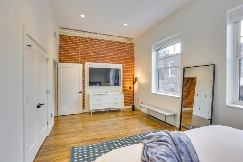 a bedroom with a bed and a brick wall at Downtown Omaha Getaway with Deck and Gas Grill! in Omaha