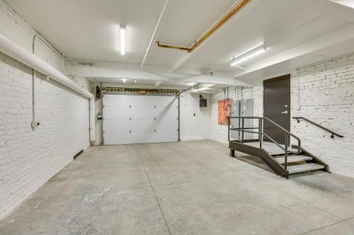 an empty room with a garage door and a staircase at Downtown Omaha Getaway with Deck and Gas Grill! in Omaha