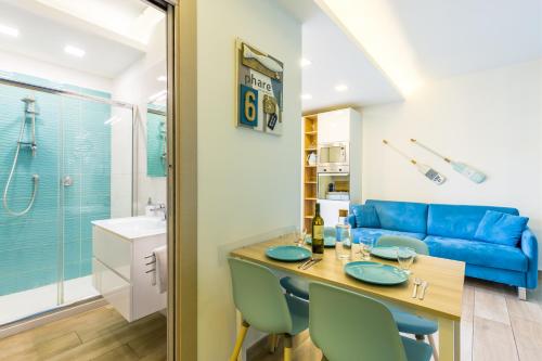 kuchnia i salon z niebieską kanapą w obiekcie Il Riccio di Mare a 5 minuti da Sorrento w mieście Sant'Agnello