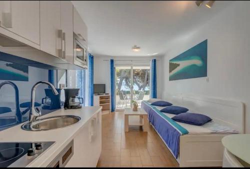 a kitchen with a bed and a sink in a room at Apartment Promenade Zlatni Rat in Bol
