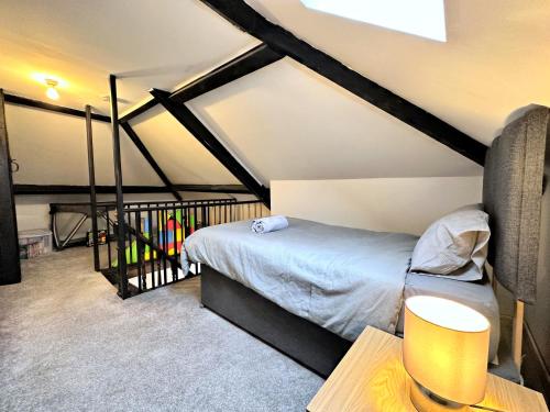 a attic bedroom with a bed and a table at Large house on the edge of the Brecon Beacons in Beaufort