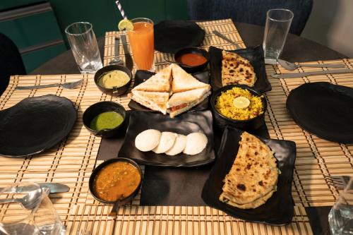 a table with plates of food on a table at Barefoot Homestays in Rāmnagar