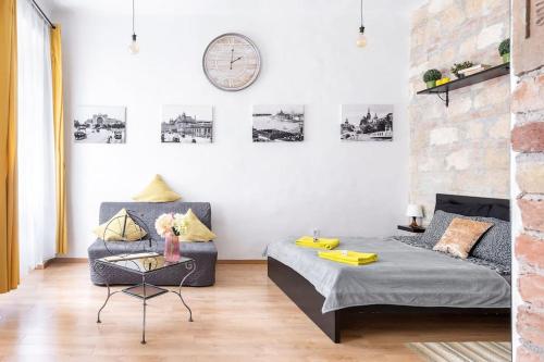 ein Schlafzimmer mit einem Bett und einer Uhr an der Wand in der Unterkunft Vintage Style Cozy Downtown Apartment. in Budapest