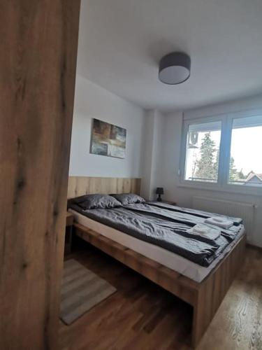 a bedroom with a bed in a room with a window at Downtown apartment in Subotica