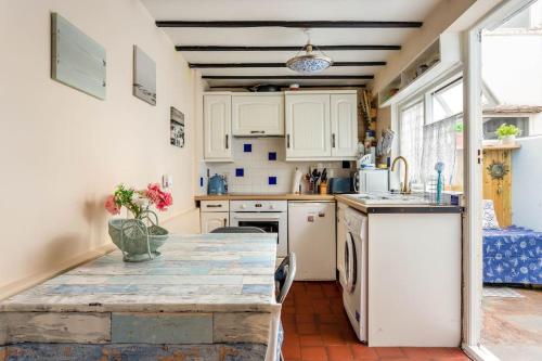 a kitchen with white cabinets and a counter top at Cute Fisherman's Cottage in the Heart of Brighton in Brighton & Hove