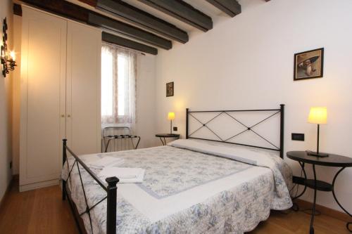 Residence dei Mori في البندقية: غرفة نوم بسرير كبير وطاولتين
