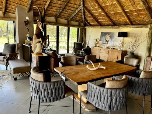 a dining room with a wooden table and chairs at Sambane Game Lodge 