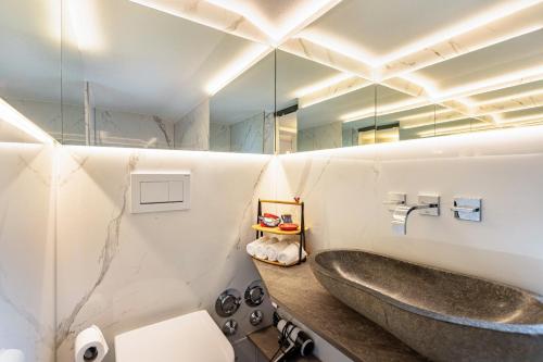Un baño con lavabo y un espejo grande. en Haus Alpenveilchen - Appartement 1, en Schönau am Königssee