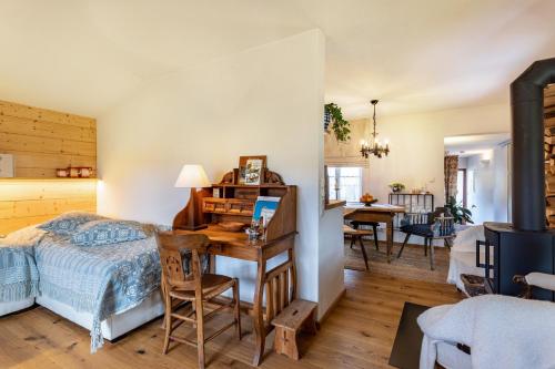 Un dormitorio con un escritorio y una cama y un comedor. en Haus Alpenveilchen - Appartement 1, en Schönau am Königssee