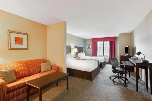 a hotel room with a bed and a couch at La Quinta by Wyndham Richmond - Kings Dominion in Doswell
