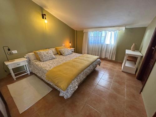 een slaapkamer met een groot bed en een raam bij Casa Abona, precioso ático con wifi gratis y vistas increíbles al mar y la montaña in La Sabinita
