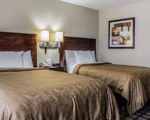 une chambre d'hôtel avec 2 lits et 2 lampes dans l'établissement MainStay Suites Coralville - Iowa City, à Coralville