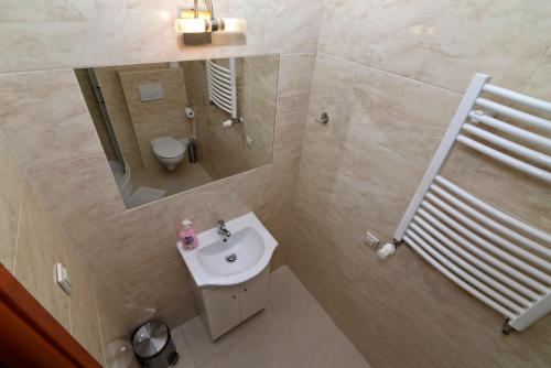 La salle de bains est pourvue d'un lavabo, d'un miroir et de toilettes. dans l'établissement Ośrodek SCSK Optima, à Cracovie