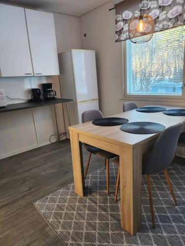 a kitchen with a wooden table and chairs and a kitchen with a window at Gáiju Apartment 