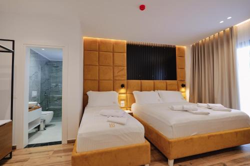 sypialnia z 2 łóżkami i dużym zagłówkiem w obiekcie HOTEL RENATO w mieście Ksamil