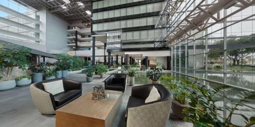 a lobby with chairs and plants in a building at Hyatt Regency Houston West in Houston