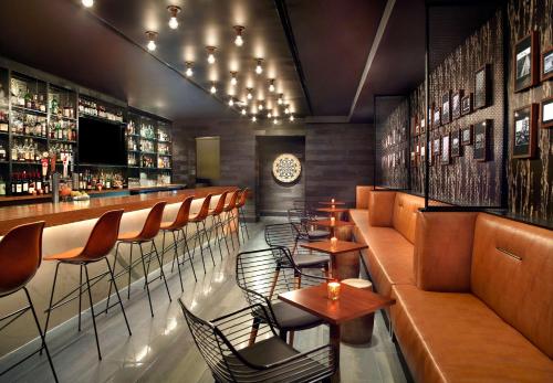 a restaurant with tables and chairs and a bar at Hyatt Regency Houston West in Houston