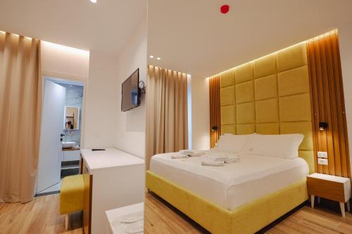 sypialnia z dużym łóżkiem z żółtym zagłówkiem w obiekcie HOTEL RENATO w mieście Ksamil