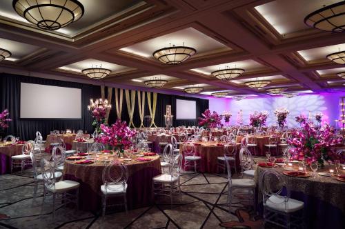 a banquet hall with tables and chairs and pink flowers at Hyatt Regency Houston West in Houston