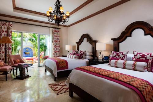 a bedroom with two beds and a chandelier at One&Only Palmilla in San José del Cabo