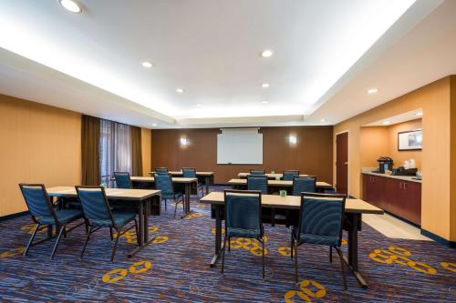 a conference room with tables and chairs and a whiteboard at Sonesta Select Detroit Novi in Novi