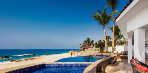 a house with a swimming pool next to a beach at One&Only Palmilla in San José del Cabo
