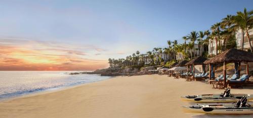 a beach with chairs and umbrellas and the ocean at One&Only Palmilla in San José del Cabo