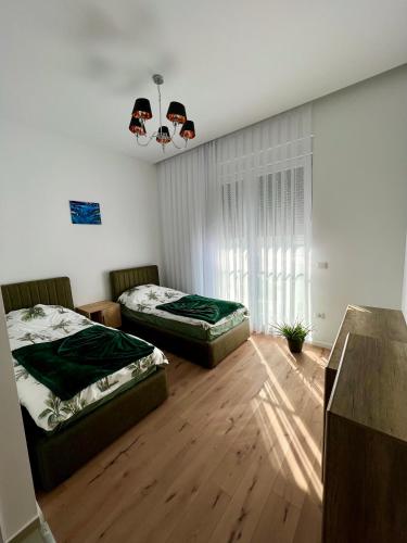 two beds in a room with wooden floors at Snooze in Prishtina in Pristina