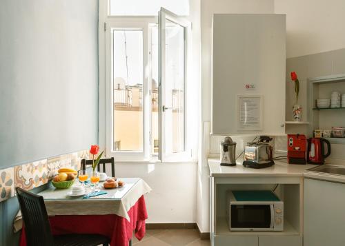 une petite cuisine avec une table et une fenêtre dans l'établissement Carafa Suite By Enjoy Napoli, à Naples