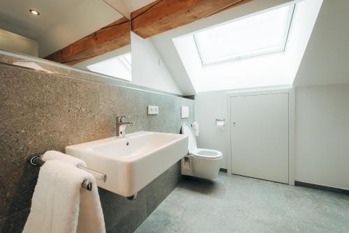 a bathroom with a sink and a toilet and a skylight at Hotel Drei König in Immenstadt im Allgäu