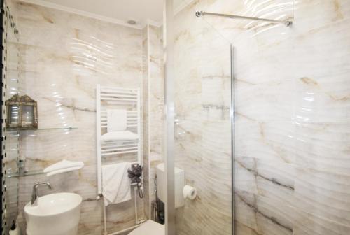 uma casa de banho com um chuveiro e um lavatório. em KAS 1Bd apartment unique central Unirii Bucharest em Bucareste